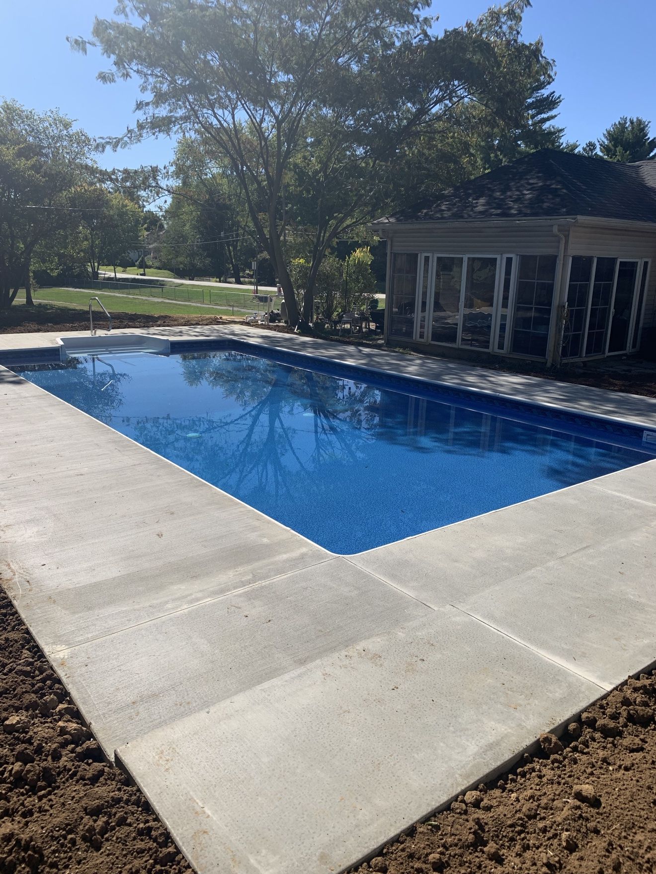 Same new inground build from an angle, beside a sunroom